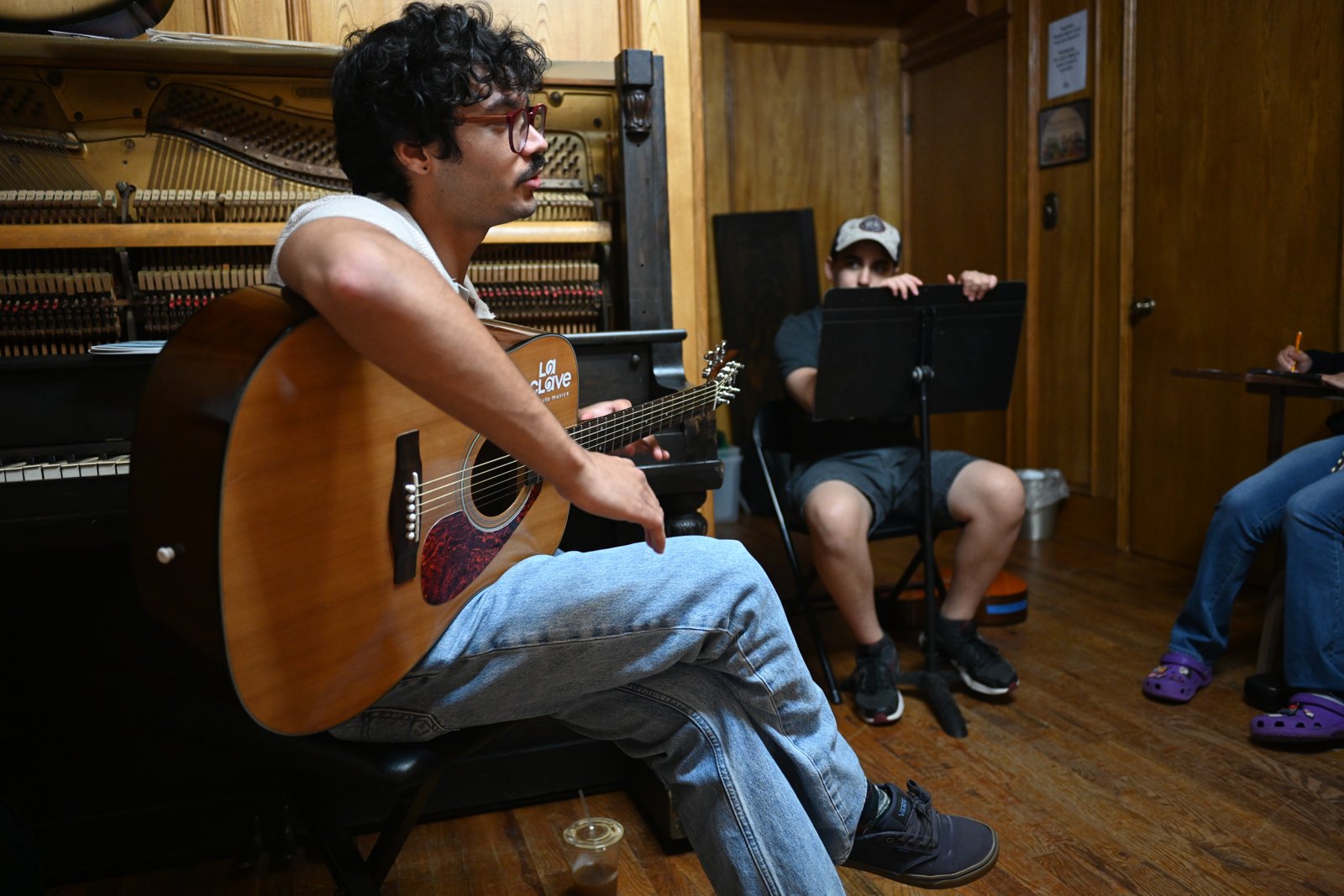 A guitarist seated in an IME classroom
