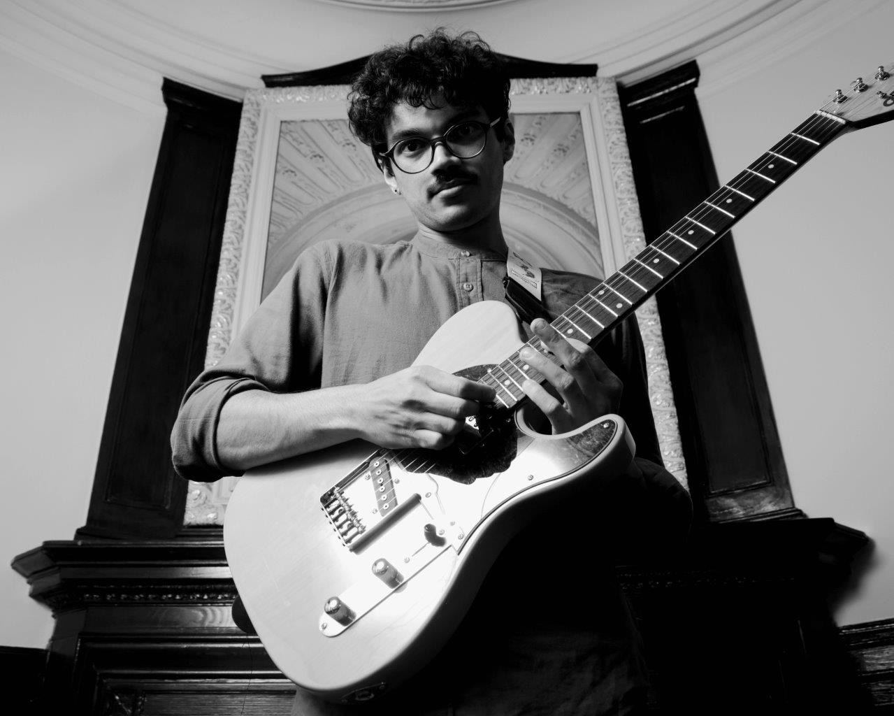 Luis McDougal with an electric guitar, black and white portrait
