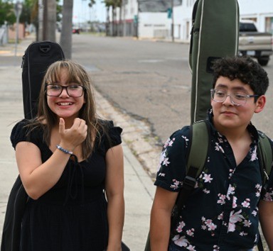 Two Sound Birth students walking to class with their instruments