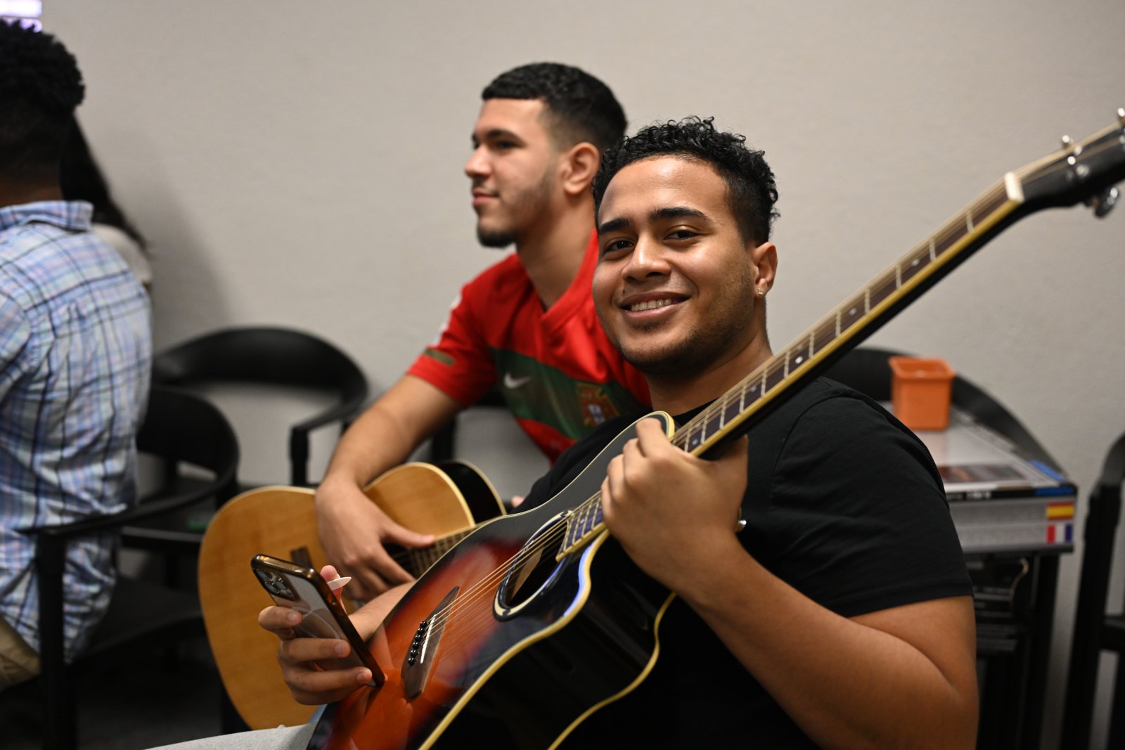 Two Sound Birth students sharing a guitar in class