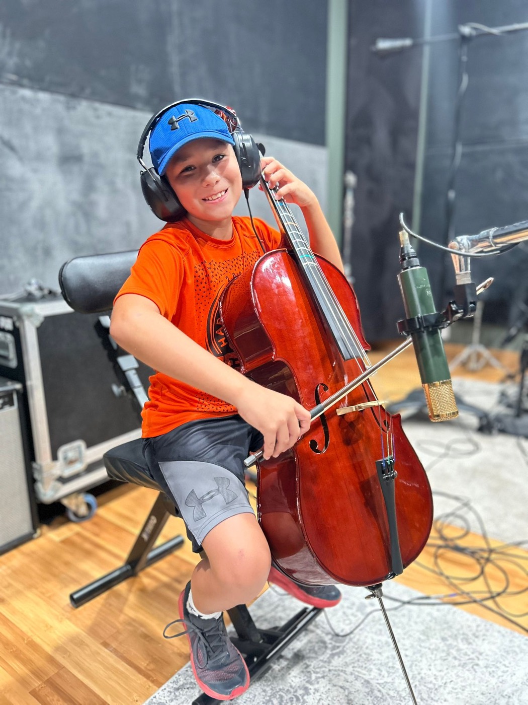 A young cellist smiling during an IME studio recording