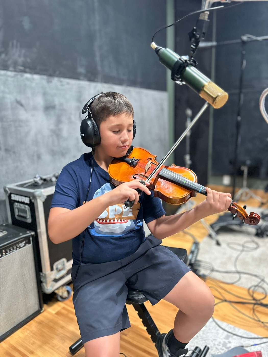 A young violinist recording with a studio microphone at Sound Birth Festival